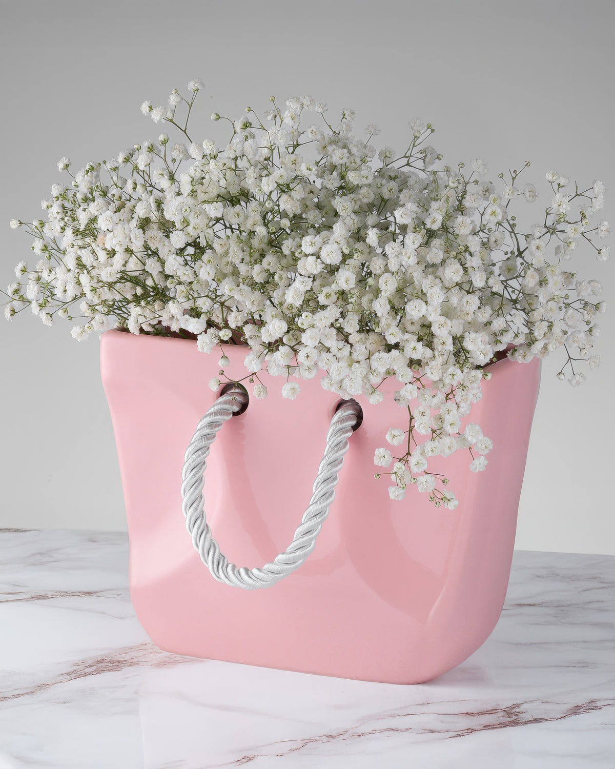 Pink ceramic handbag vase styled with flowers as a bridal shower gift and gift for her