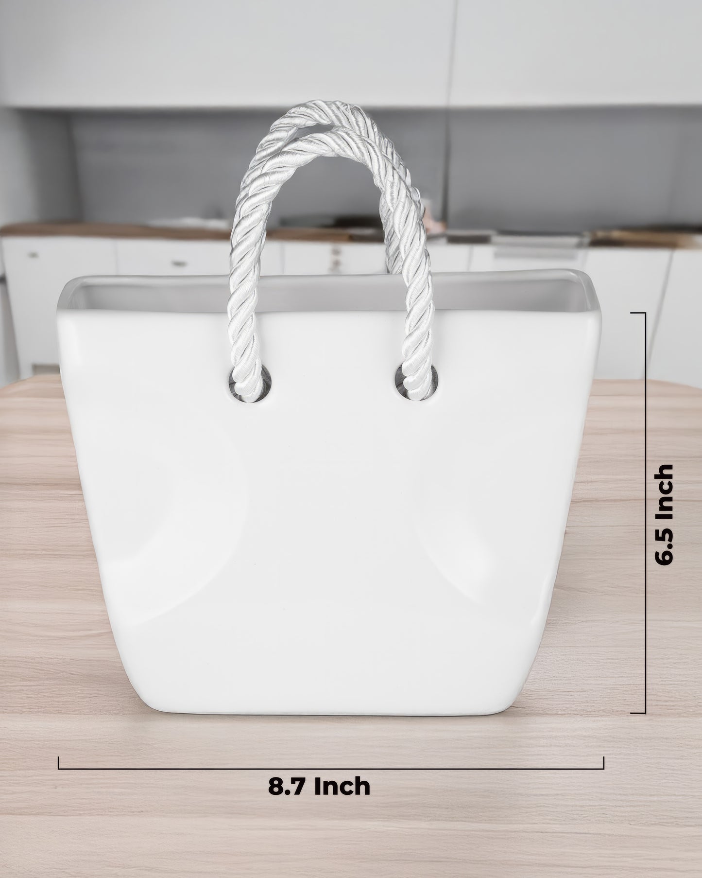 White ceramic purse vase with twisted rope handles held in hand against a plaid shirt, aesthetic flower vase