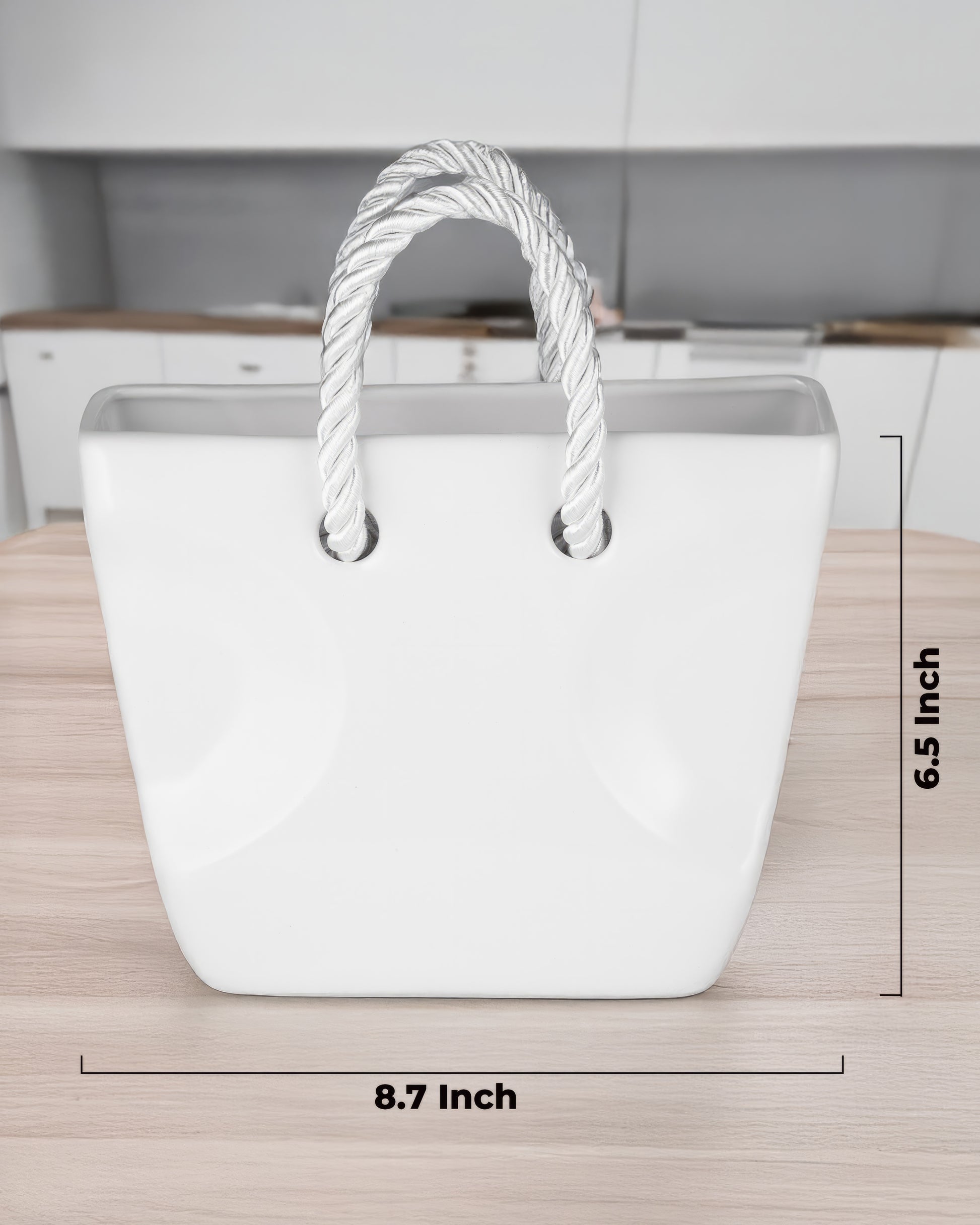 White ceramic purse vase with twisted rope handles held in hand against a plaid shirt, aesthetic flower vase