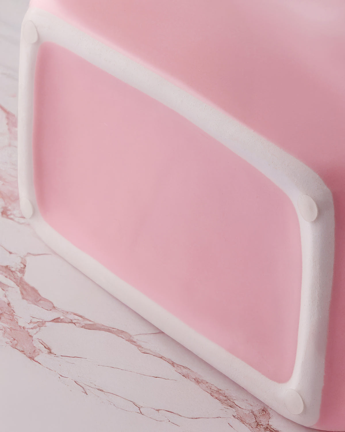 Close-up of the twisted rope handles on a blush pink ceramic purse vase