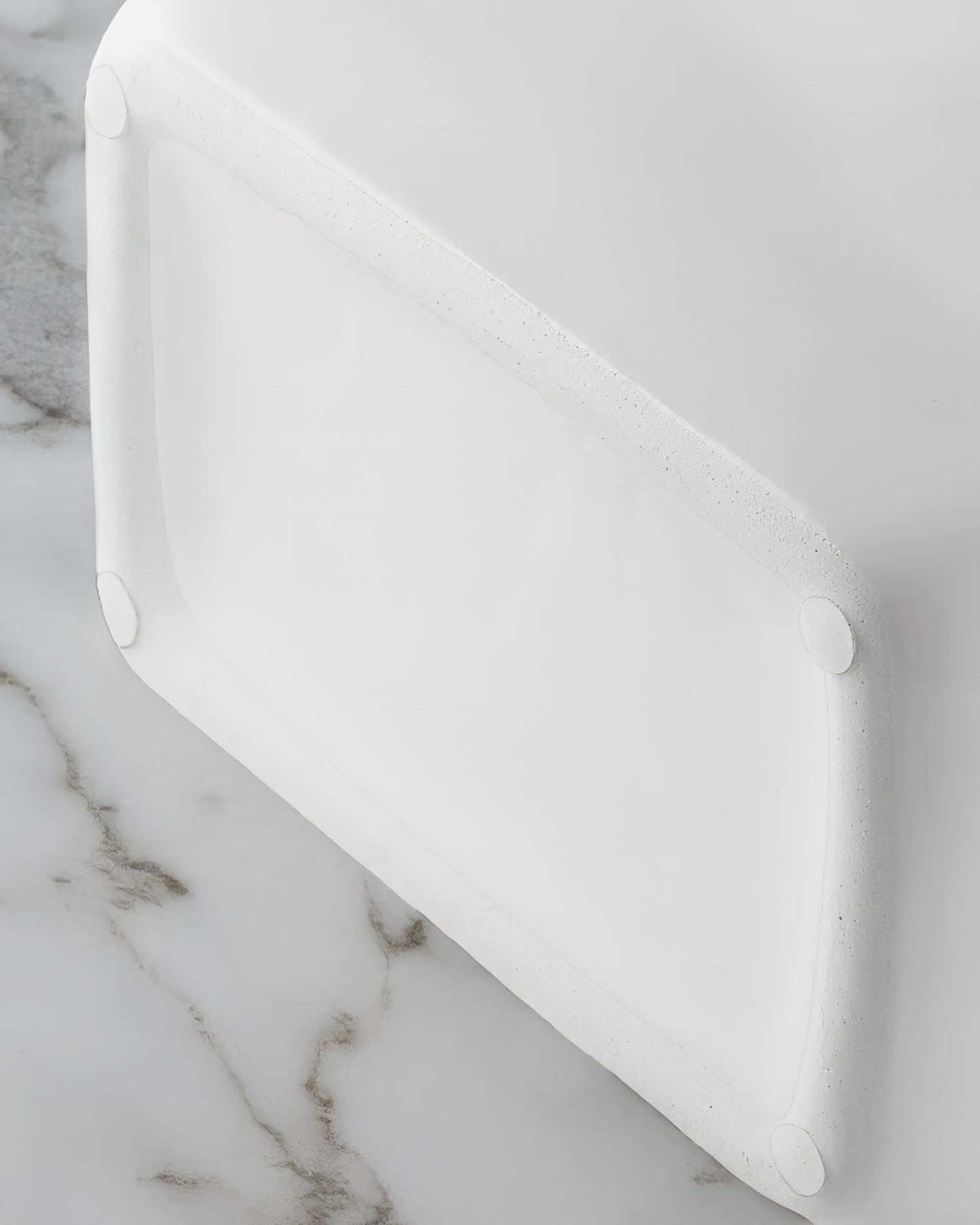 Close-up of the twisted silver rope handles on a glossy white ceramic purse vase