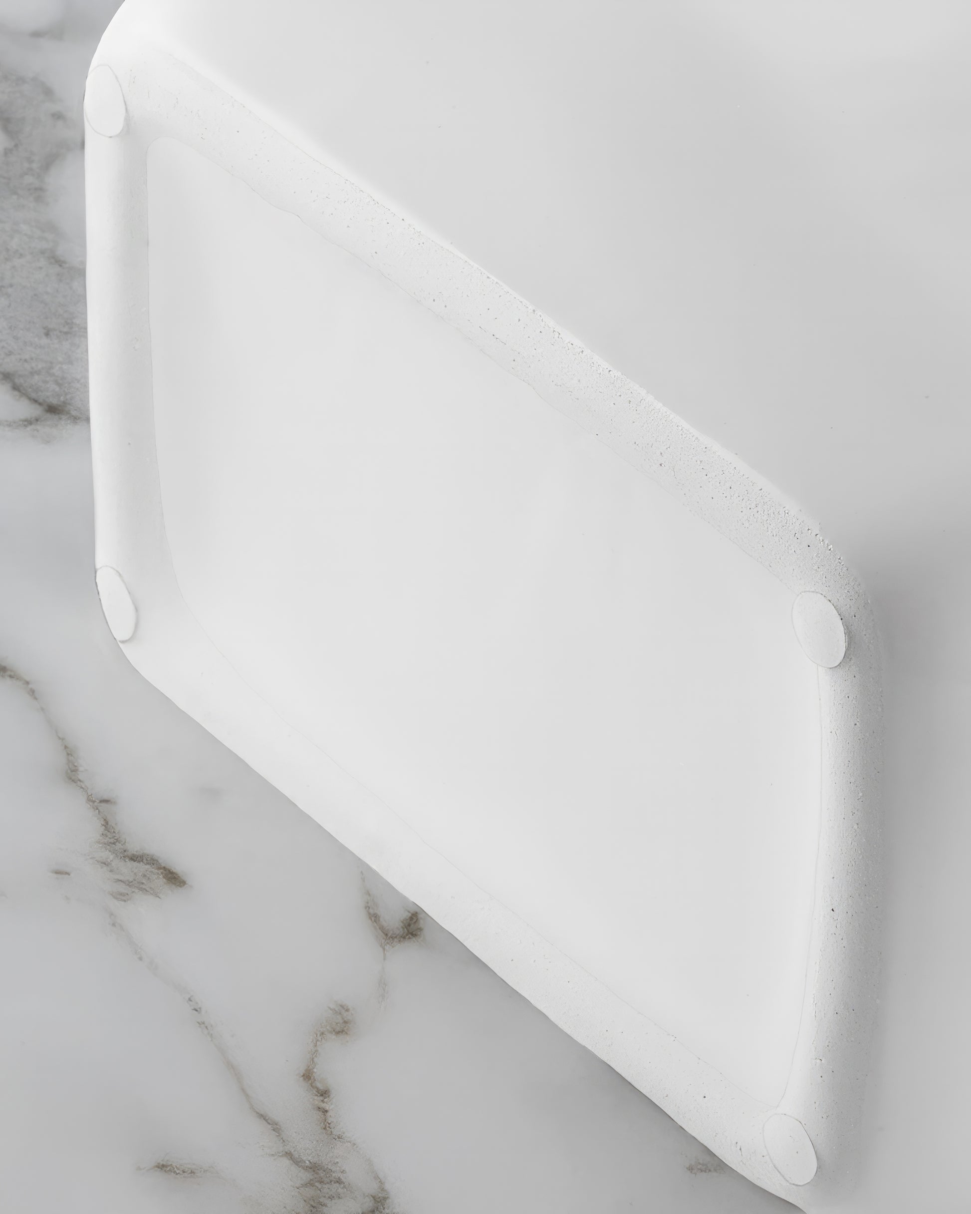 Close-up of the twisted silver rope handles on a glossy white ceramic purse vase